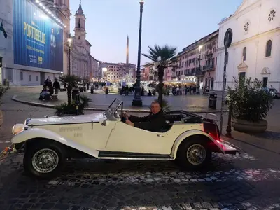 a man sitting in an old car on a street at Rome Nest at Campo De Fiori and Navona Square in Rome