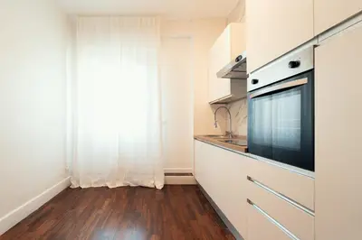 a kitchen with white cabinets and a large window at Sweet Heaven Apartment in Rome