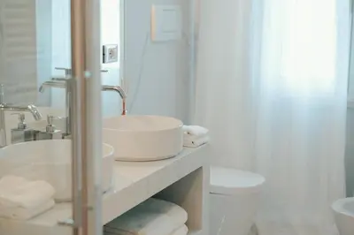 a white bathroom with a sink and a toilet at Sweet Heaven Apartment in Rome