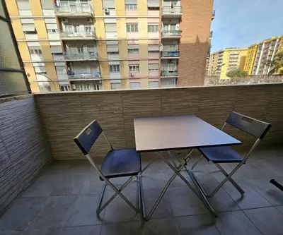 a table and two chairs on a balcony with a building at Simone House in Rome