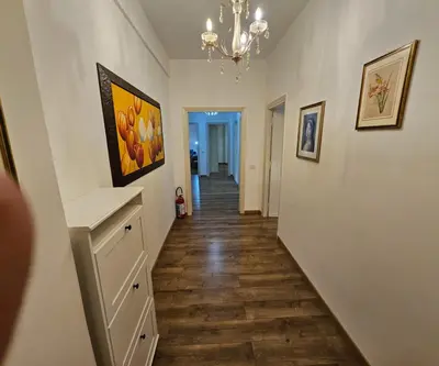 a hallway with white walls and wooden floors and a chandelier at Simone House in Rome