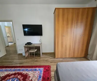 a bedroom with a wooden cabinet and a desk with a television at Simone House in Rome