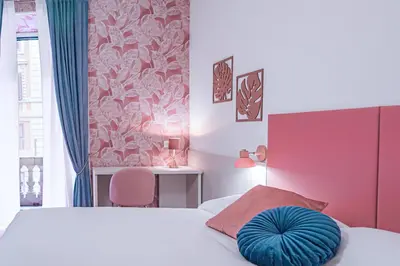 a bedroom with a bed with a blue pillow on it at Lele Rooms Vaticano in Rome