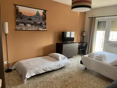 a bedroom with two beds and a desk in it at Panoramic penthouse 10m from metro A in Rome