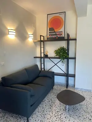 a living room with a blue couch and a table at Panoramic penthouse 10m from metro A in Rome
