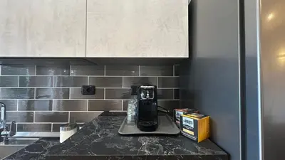 a kitchen counter with a coffeemaker on a counter top at Dolce Sosta Vatican Home close to St Peter's in Rome