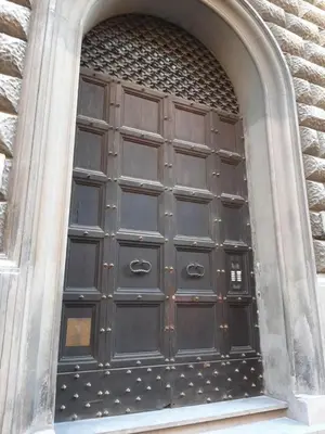 a large wooden door in a stone building at Stradivari in Rome