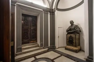 a statue of a man sitting on a chest in a room at Stradivari in Rome