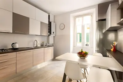 a kitchen with a white table and white chairs at Idyllia - Spacious bright flat in Rome
