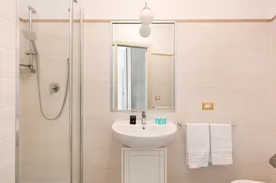 a bathroom with a sink and a shower with a mirror at Idyllia - Spacious bright flat in Rome