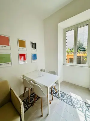 a white dining room with a white table and chairs at Gattamelata in Rome