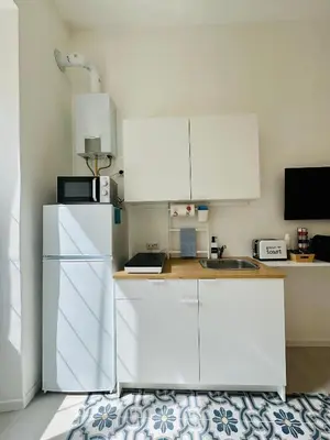 a kitchen with white cabinets and a refrigerator at Gattamelata in Rome