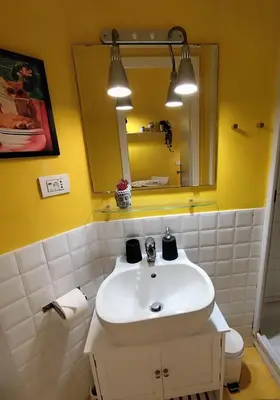 a bathroom with a white sink and a mirror at COLOSSEUM Studio Flat in Rome