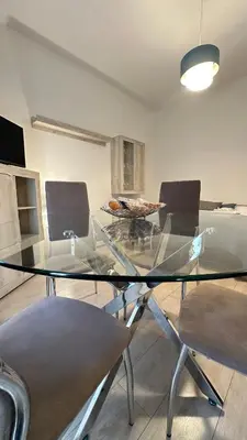 a glass table in a living room with chairs at Vatican YH in Rome