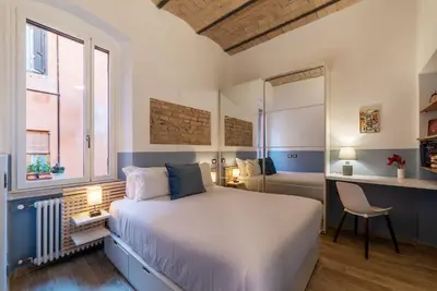 a bedroom with a bed and a desk with a chair at Orti Apartment - Charme Holidays in Rome