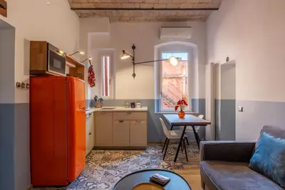 a living room with a couch and a kitchen at Orti Apartment - Charme Holidays in Rome