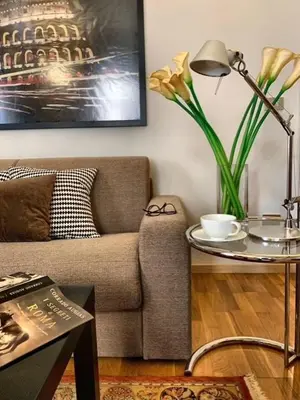 a living room with a couch and a table with a lamp at San LoFt in Rome