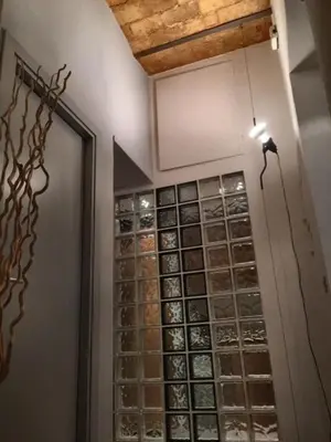 a room with a wall filled with glass wine bottles at San LoFt in Rome