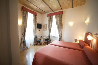 a bedroom with a red bed and a table at Villa Paganini B&B in Rome