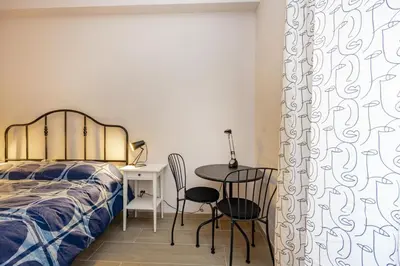 a bedroom with a bed and a table and chairs at La Dimora di Margot in Rome