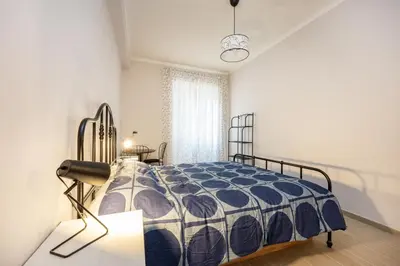 a bedroom with a bed and a table and a window at La Dimora di Margot in Rome