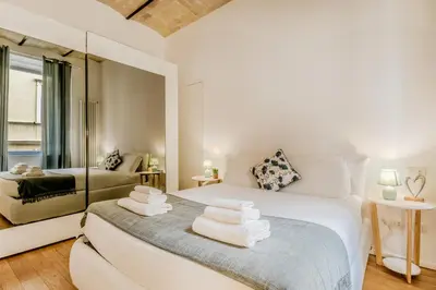 a bedroom with a white bed and a mirror at Bibi Home - Vaticano in Rome