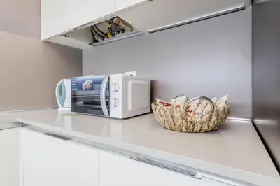a kitchen counter with a microwave and a basket at Bibi Home - Vaticano in Rome