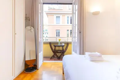 a bedroom with a bed and a view of a table at Elegantis Solinda Suite Apartment with Private Terrace - Steps from Metro, Tram & Bus to Rome's Historic Center in Rome