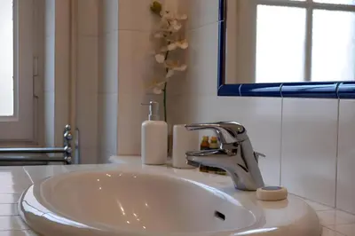 a bathroom sink with a faucet and a mirror at Elegantis Solinda Suite Apartment with Private Terrace - Steps from Metro, Tram & Bus to Rome's Historic Center in Rome
