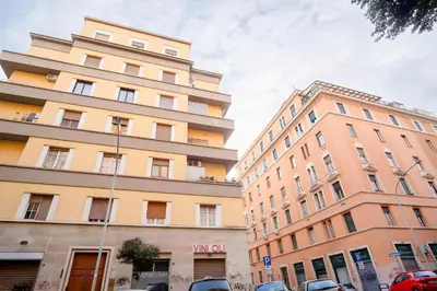 two tall buildings with cars parked in front of them at Elegantis Solinda Suite Apartment with Private Terrace - Steps from Metro, Tram & Bus to Rome's Historic Center in Rome