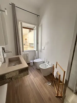 a white bathroom with a tub and a sink at Casa da favola Roma in Rome