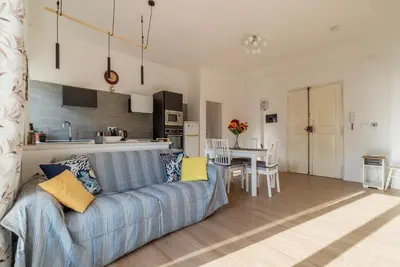 a living room with a blue couch and a kitchen at GuestHost - RM Veio 52B in Rome