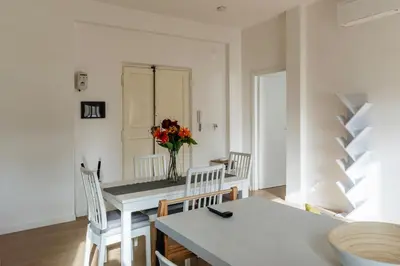 a dining room with a table and chairs and a vase of flowers at GuestHost - RM Veio 52B in Rome