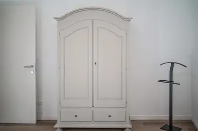 a white cabinet in a white room with a cross at Domus Iulia, Trastevere in Rome