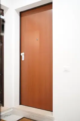 a brown door in a white room with a rug at Domus Iulia, Trastevere in Rome