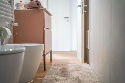 a bathroom with a white toilet and a rug at Domus Iulia, Trastevere in Rome