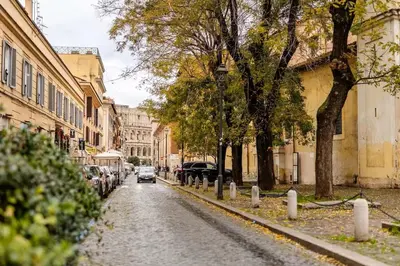 a car driving down a street with trees and buildings at Luxe Escape Colosseo in Rome