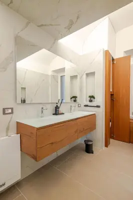 a bathroom with a sink and a large mirror at Luxe Escape Colosseo in Rome