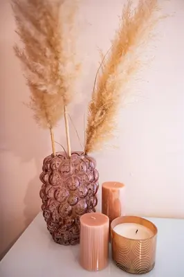 a vase with feathers and two candles on a table at Deluxe Spanish Steps in Rome