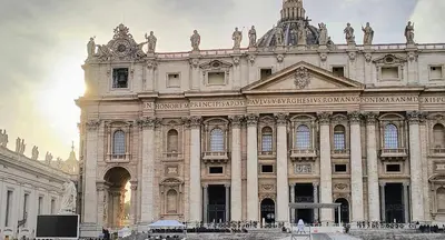 a large building with the sun setting behind it at The Apartment in Rome