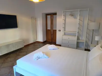 a bedroom with a white bed with a tv on the wall at The Apartment in Rome