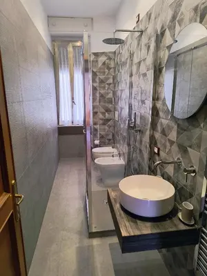 a bathroom with a sink and a toilet and a mirror at The Apartment in Rome