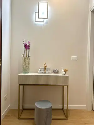 a table with a stool and a vase with flowers at Maryam Vatican Suites in Rome