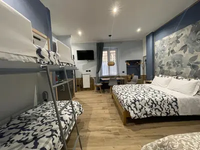 a bedroom with two beds and a living room at Helle Hus - 4 min to Metro, Modern & Quiet, Direct to Colosseum in Rome