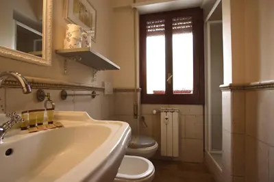 a white bathroom with a sink and a toilet at Margherita Holiday Home in Rome