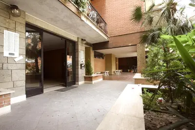 an empty courtyard of a building with glass doors at Margherita Holiday Home in Rome