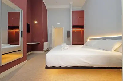 a bedroom with a large white bed and a mirror at Velvet Inn in Rome