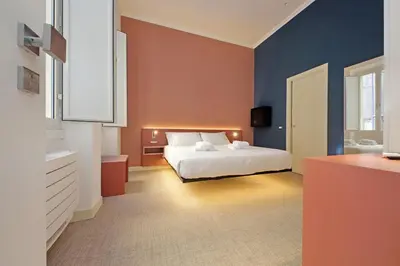 a bedroom with a white bed and a blue wall at Velvet Inn in Rome