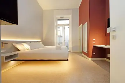 a bedroom with a large white bed and orange walls at Velvet Inn in Rome