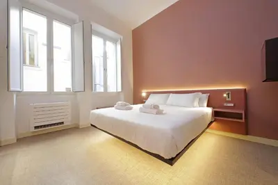 a bedroom with a large white bed and windows at Velvet Inn in Rome